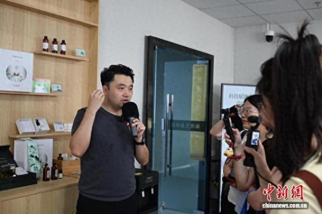 近日，王思佳向参观者介绍产品。中新社记者 满会乔 摄